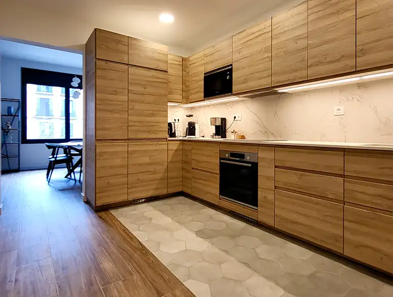 Image of an open-plan kitchen made with wood and porcelain stoneware in marble effect
